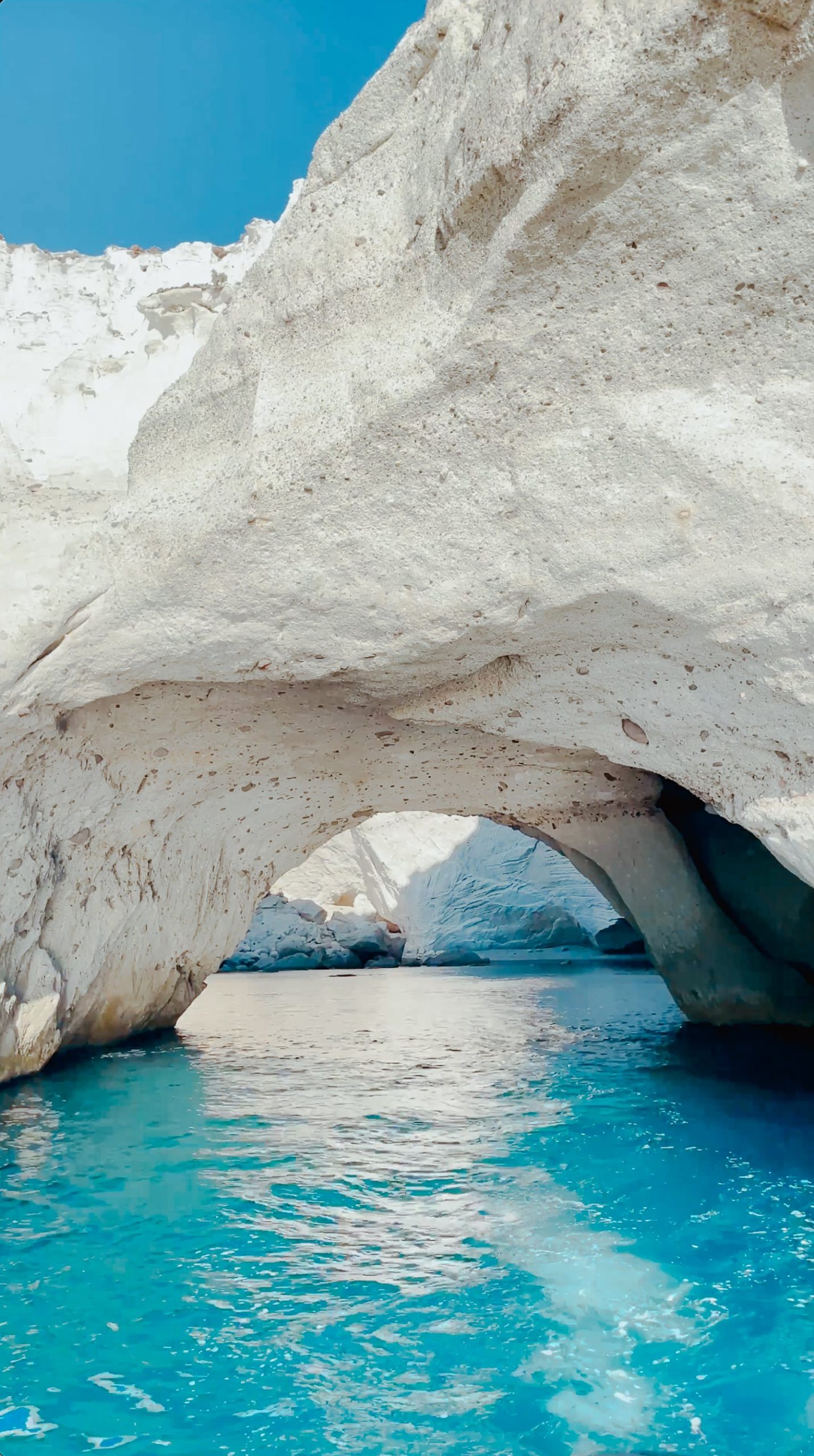 Natural sea cave with white rock formations and turquoise water at Sikia Cave near Kleftiko, Milos, Greece.
