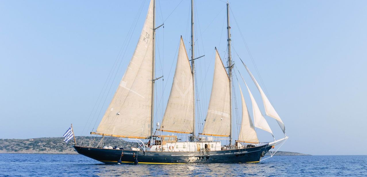 SIR WINSTON CHURCHILL classic sailing yacht with tan sails cruising off the Greek coast

